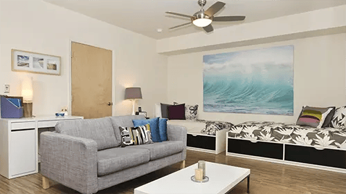 Sofa, beds, desk, wave art living room at ICON in Goleta Student Accommodation
