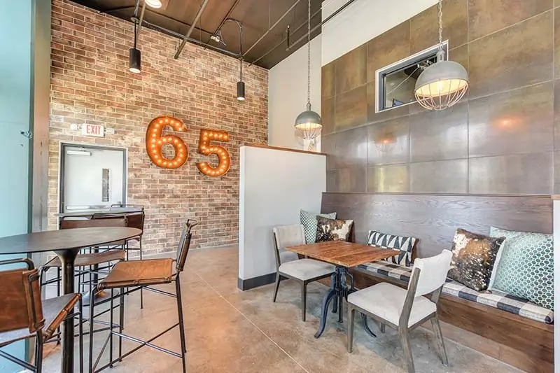 Exposed brick large number 65 bar seating lounge area at Academy65 in Sacramento Student Accommodation