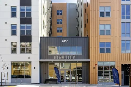 Building with large windows and 'Identity' signage exterior at IDENTITY Logan Park in Berkeley Student Accommodation