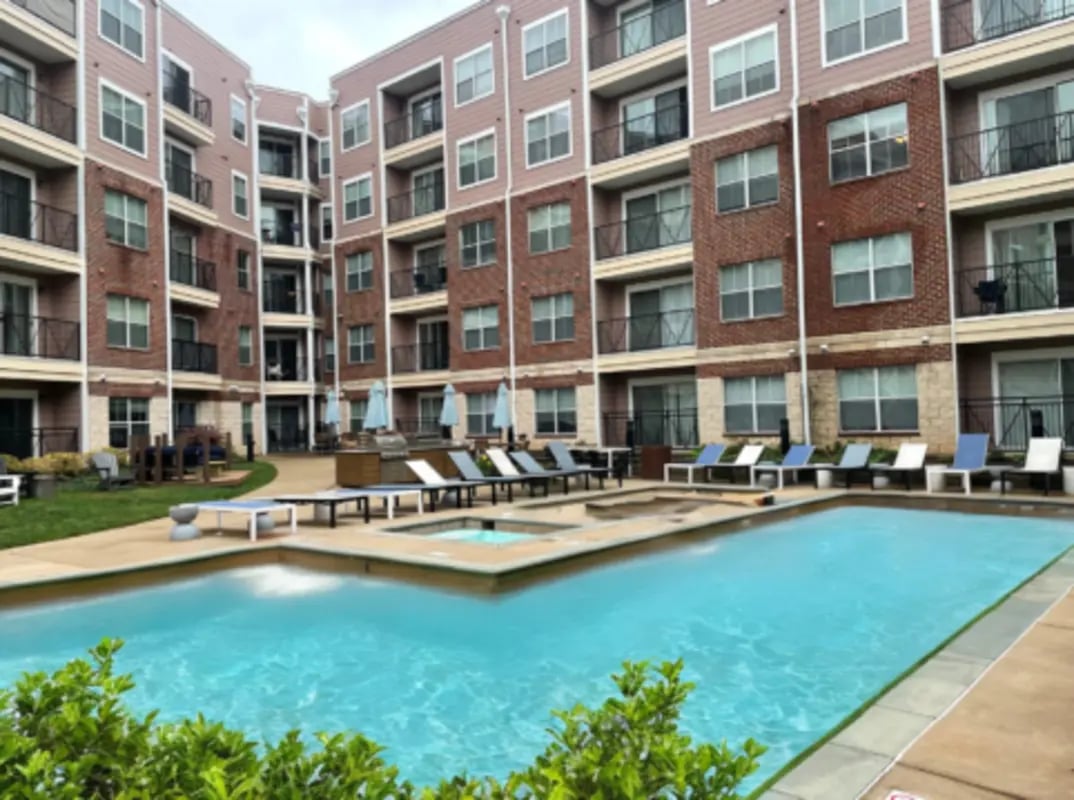 Apartment complex courtyard with swimming pool and lounge chairs exterior at Grandmarc at The Corner in Charlottesville Student Accommodation