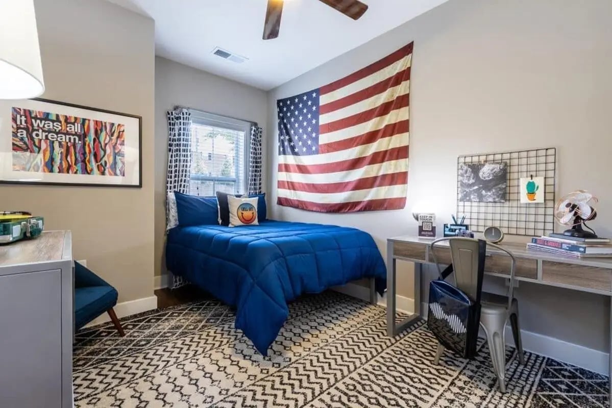 Blue bed desk American flag bedroom at The Eastern On 10th in Greenville Student Accommodation