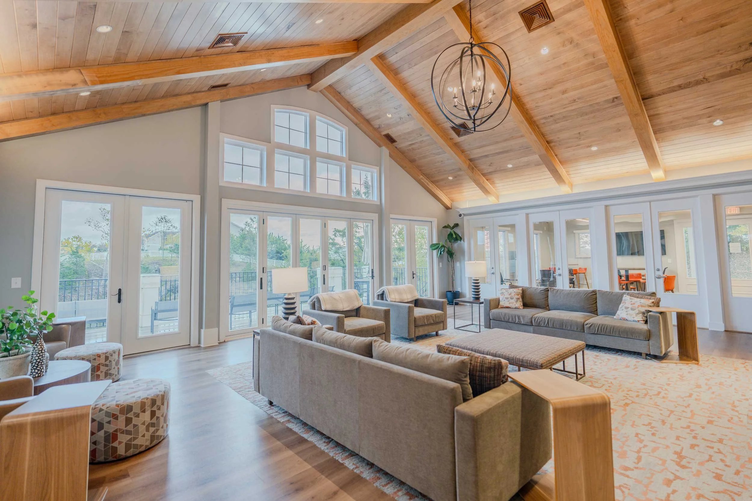 Modern living room with sofas tables and large windows living room at Maple Ridge Townhomes in Blacksburg Student Accommodation