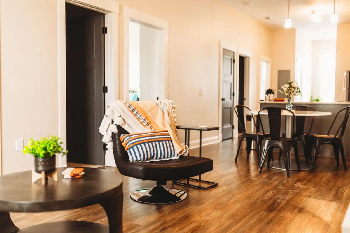 Armchair dining table and chairs living room at College Corners on High in Farmville Student Accommodation