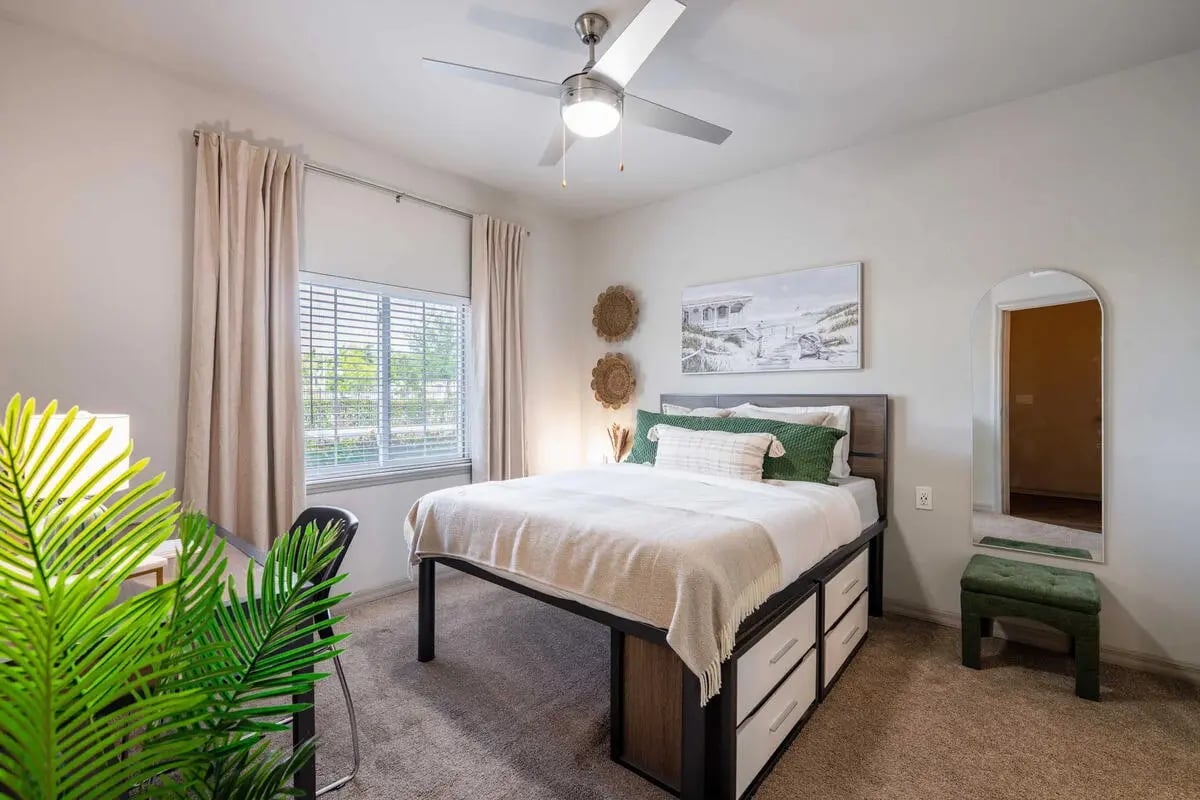Bed with storage drawers green accents arched mirror bedroom at The Reef Student Living in Fort Myers Student Accommodation