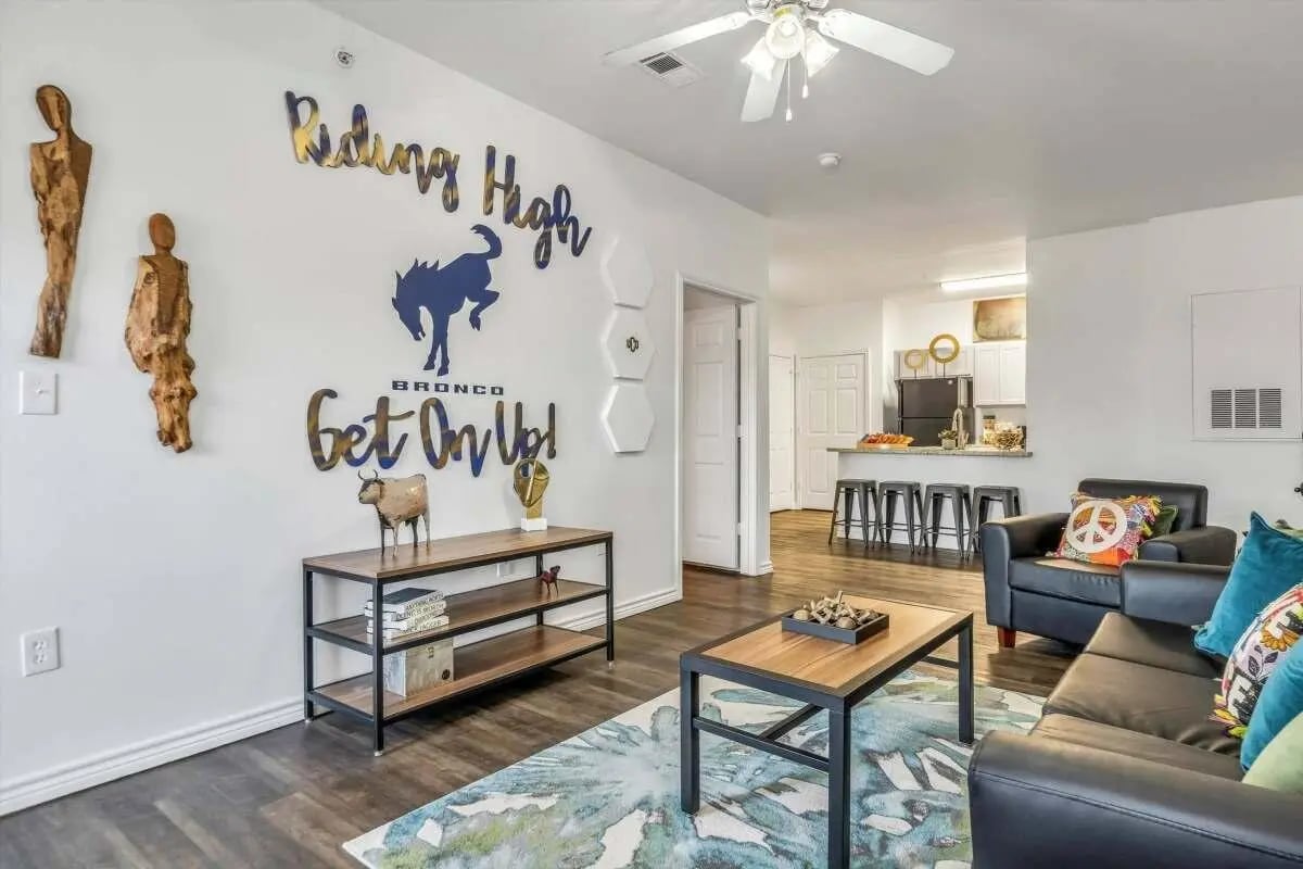 Wall art couch coffee table kitchen living room at The Rendezvous Apartments in Edmond Student Accommodation
