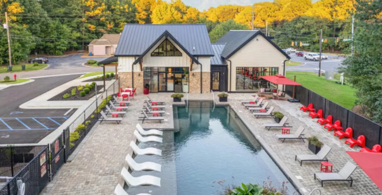 Poolside lounge chairs and umbrellas exterior at Hillside Commons in Tuscaloosa Student Accommodation