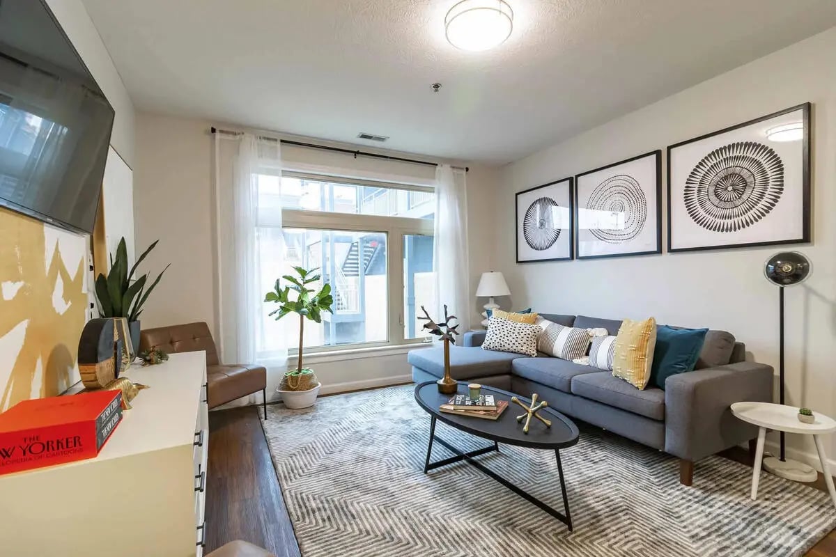 Grey sectional sofa artwork and coffee table living room at PPG East Village in Columbus Student Accommodation