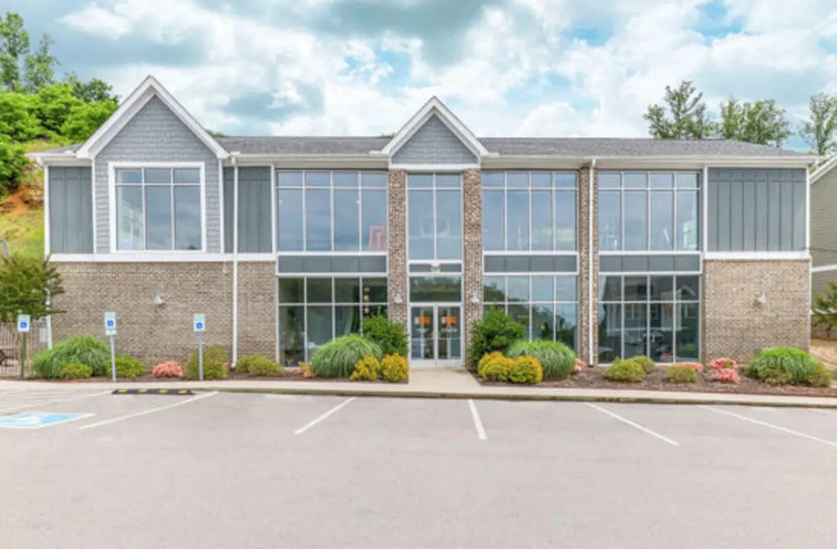 Modern building with large windows and parking exterior at Knox Ridge in Knoxville Student Accommodation