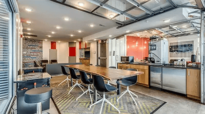 Long table chairs kitchen appliances and arcade game area lounge at The View on High in Columbus Student Accommodation