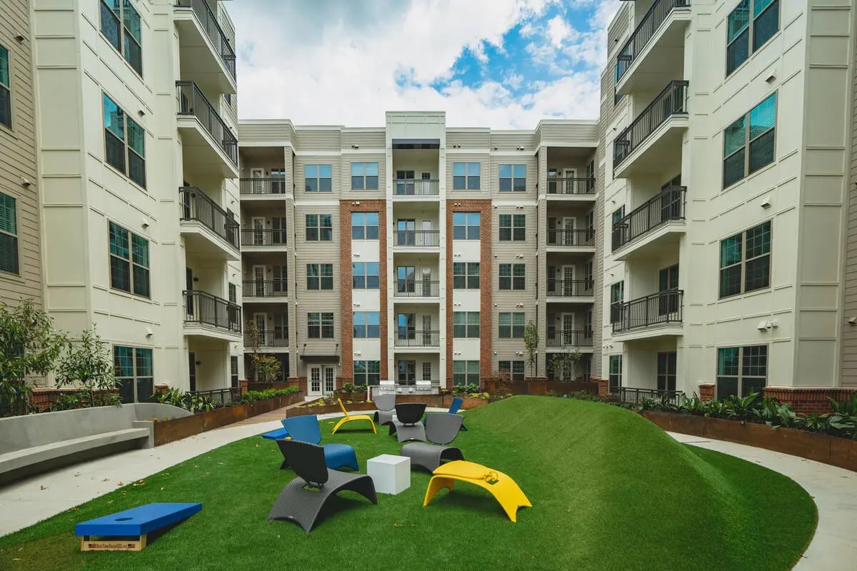 Courtyard with seating and cornhole exterior at Paloma West Midtown in Atlanta Student Accommodation