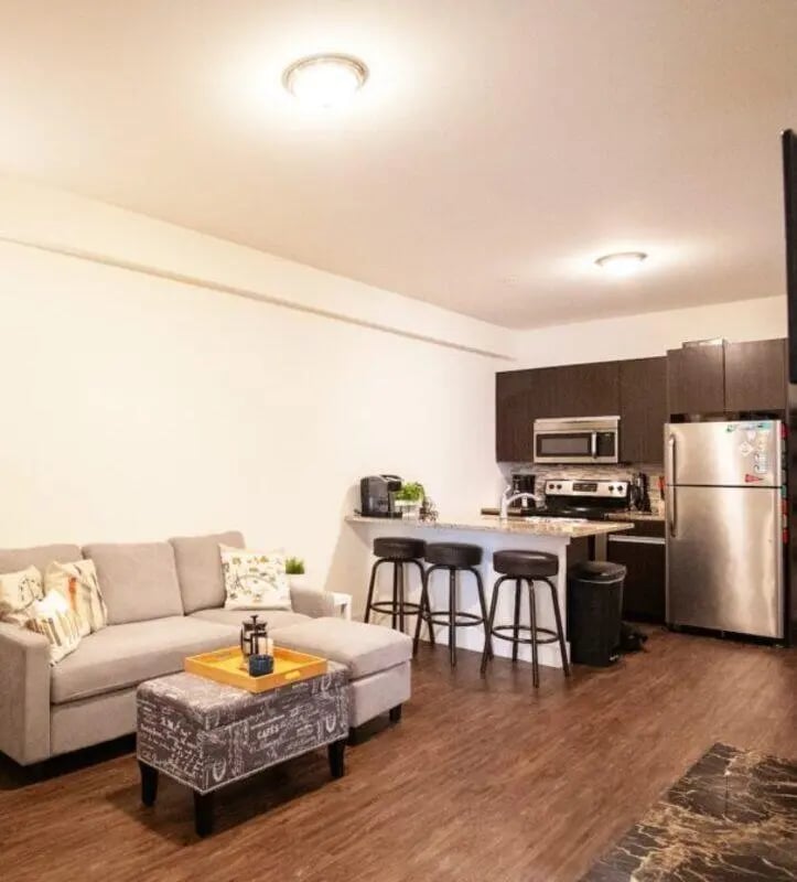 Sofa ottoman kitchen with stools and fridge Living room kitchen at The Eleanor at Chestnut Apartments in Philadelphia Student Accommodation