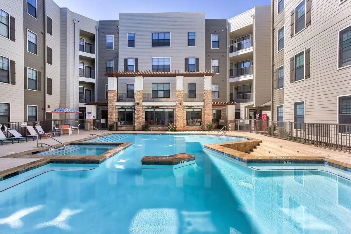 Swimming pool and hot tub with lounge chairs exterior at Maverick Place Apartments in Arlington Student Accommodation
