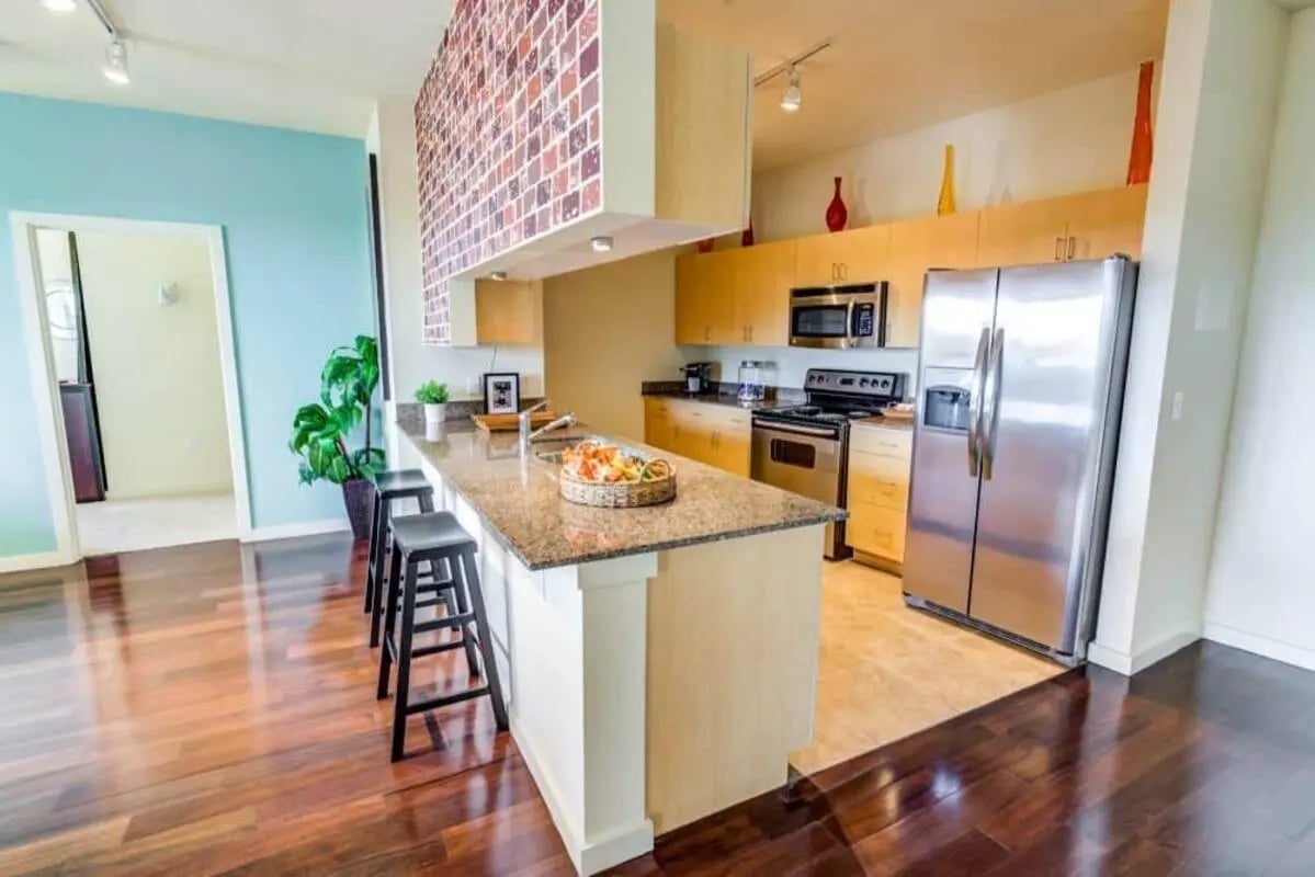 Kitchen island with stools stainless steel appliances kitchen at Venue On Guadalupe in Austin Student Accommodation