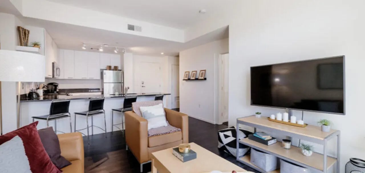 Sofa chairs kitchen island television living room at Vertex Apartments in Tempe Student Accommodation