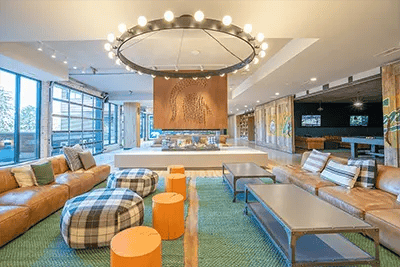 Brown sofas fireplace modern chandelier living room at Landmark on Grand River in East Lansing Student Accommodation
