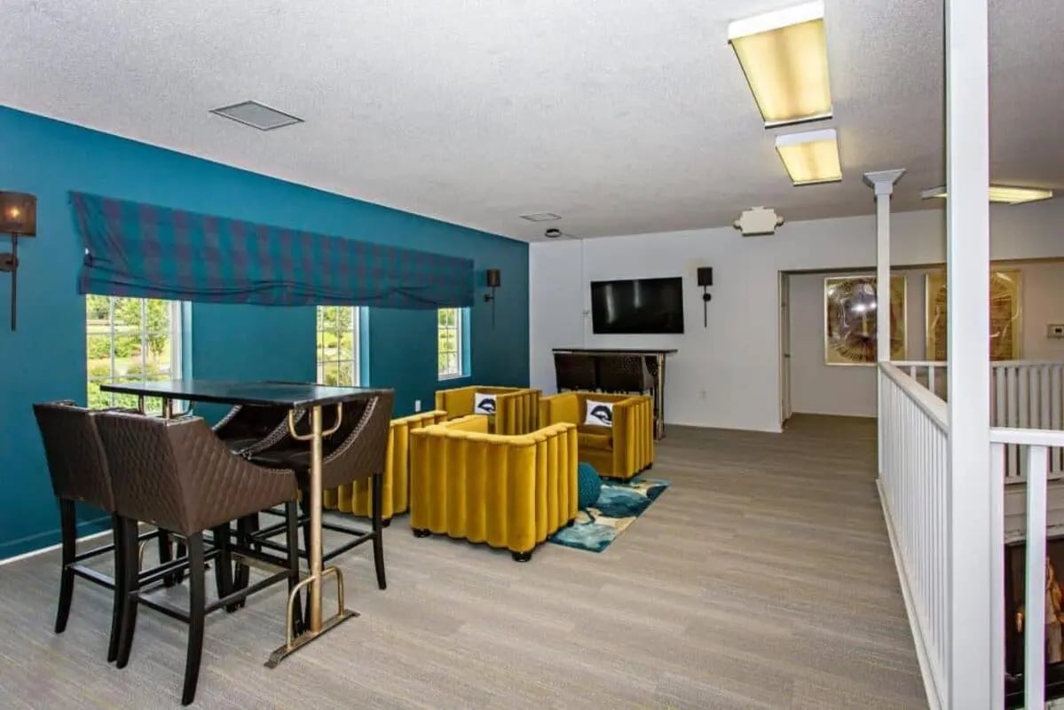 Bar table with stools yellow chairs living area at University Village At Clemson in Central Student Accommodation