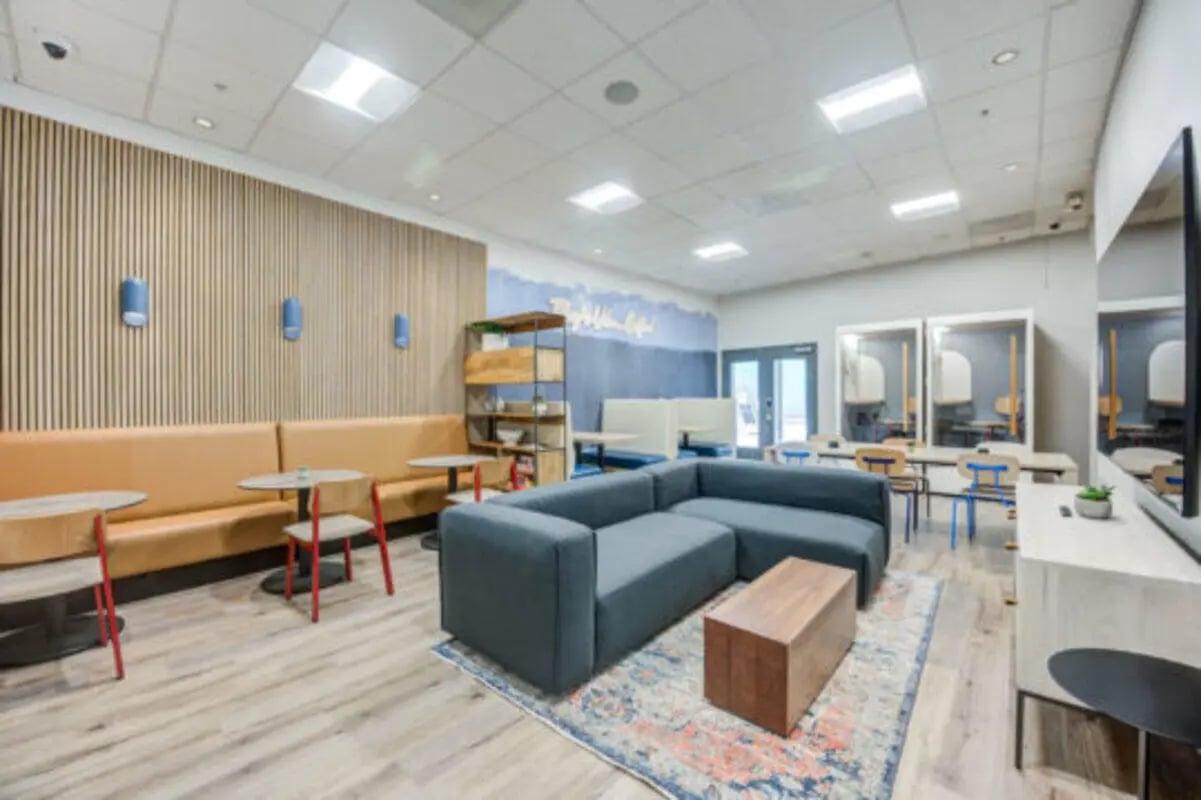 Modern lounge with sectional sofa and booths living room at University Village Towers in Riverside Student Accommodation