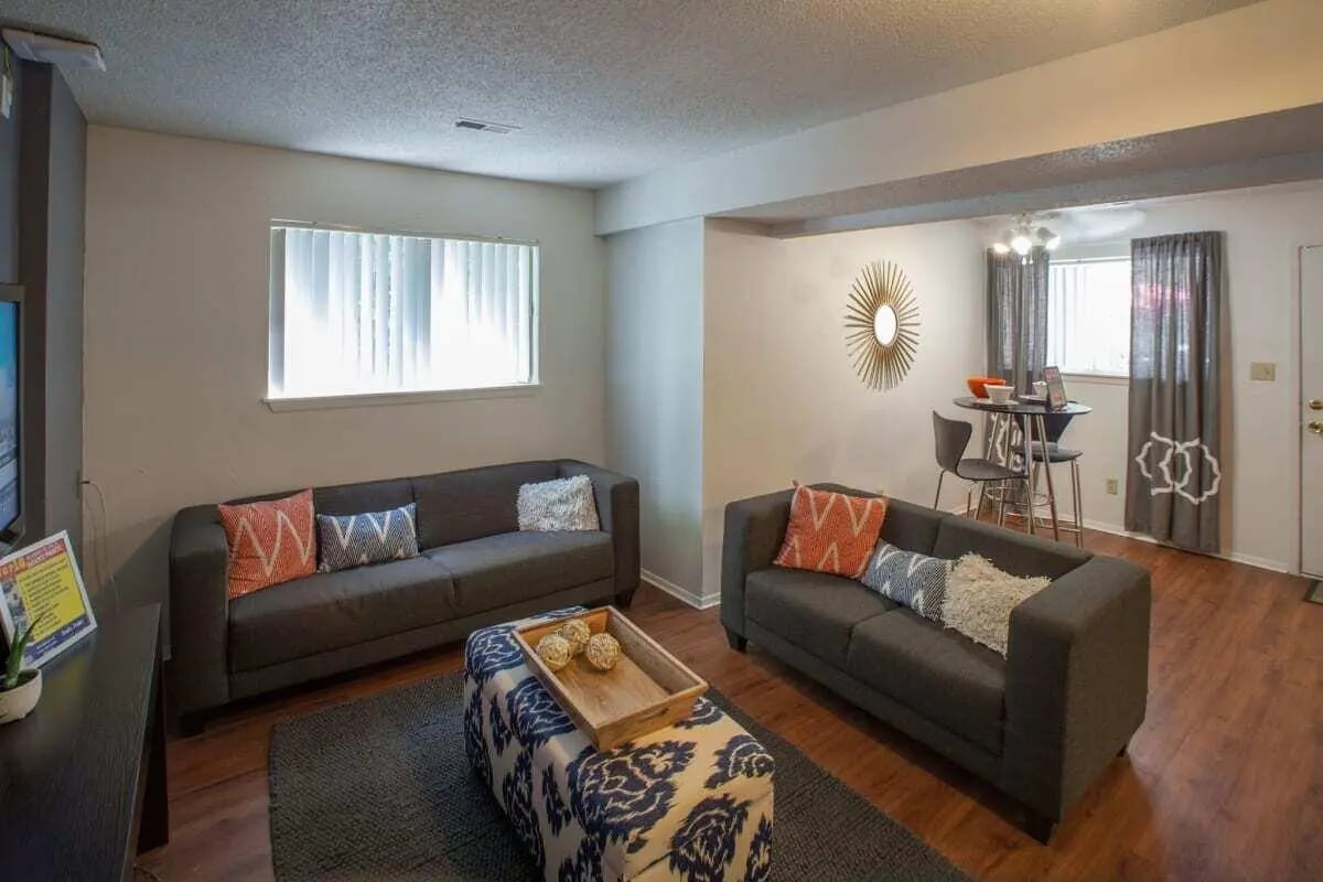 Two sofas ottoman and dining table living room at Hawks Pointe in Lawrence Student Accommodation