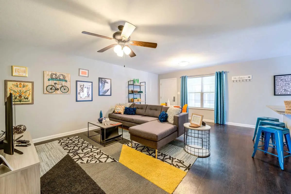 Grey sectional couch rug and TV living room at The Commons at Knoxville in Knoxville Student Accommodation