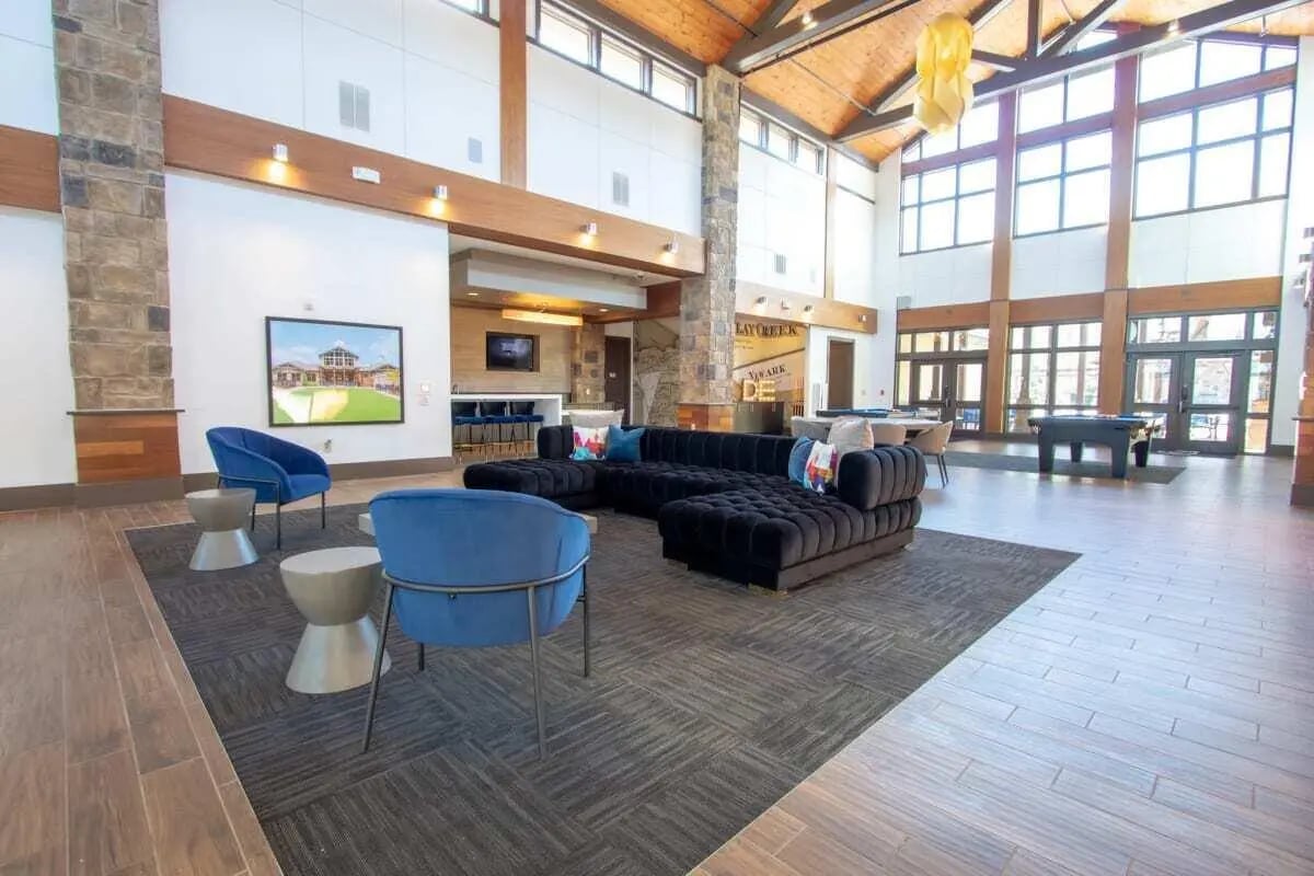 Modern lounge with black sectional blue chairs living area at The Waverly in Newark Student Accommodation