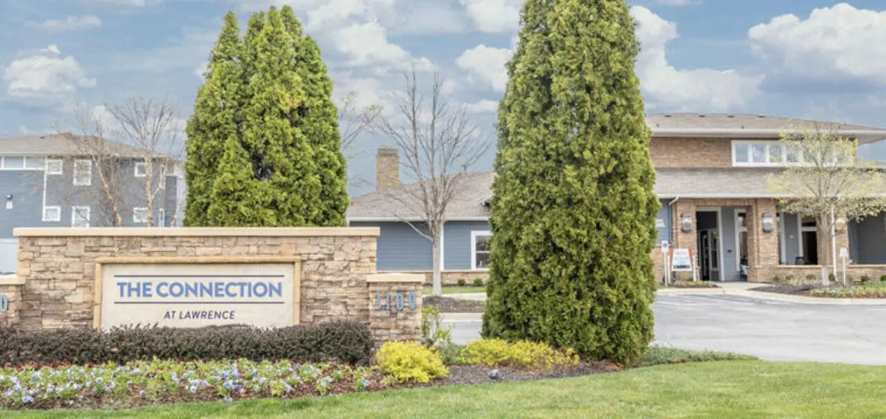 Stone sign trees building exterior at The Connection at Lawrence in Lawrence Student Accommodation