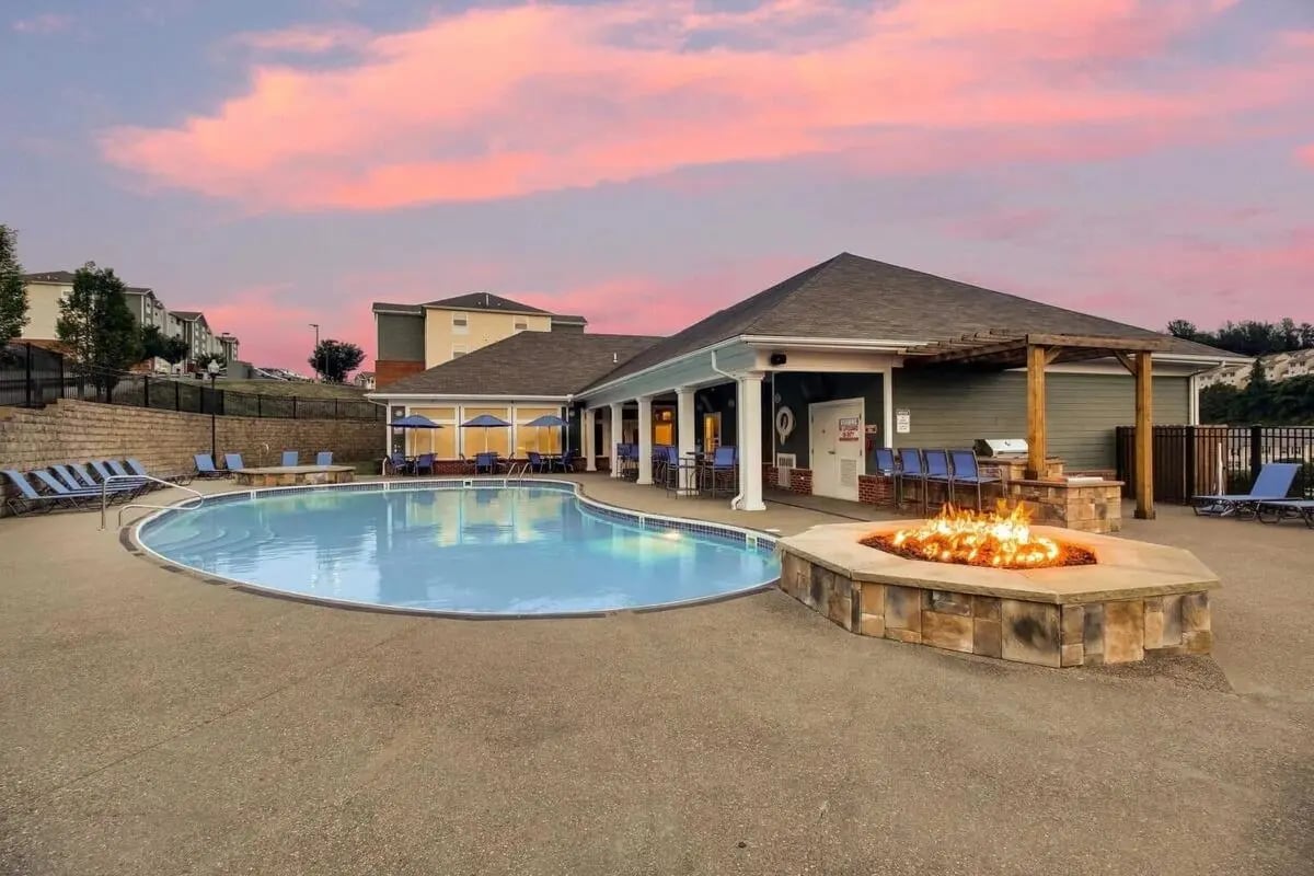 Pool with lounge chairs fire pit and buildings Exterior at West Run Morgantown in Morgantown Student Accommodation