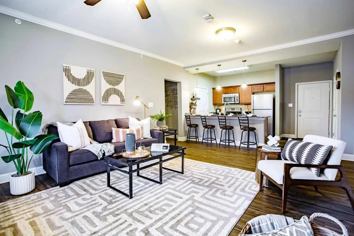 Sofa coffee table plant kitchen bar stools living room kitchen at Midtown at WKU in Bowling Green Student Accommodation