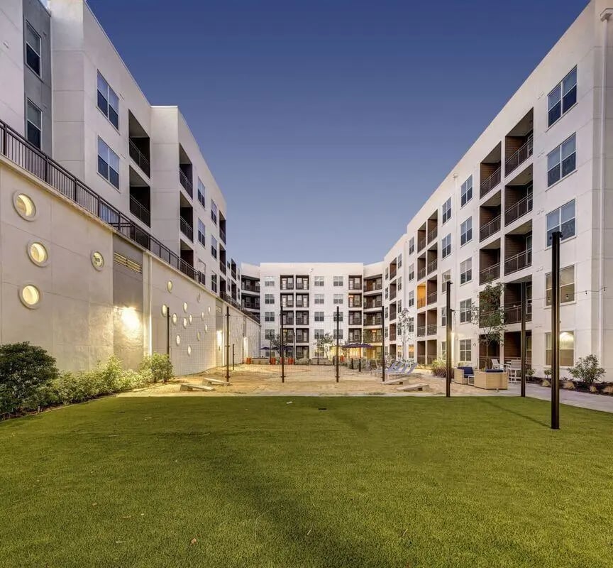 Courtyard with grassy area and apartment buildings exterior at The Lyndon in San Marcos Student Accommodation