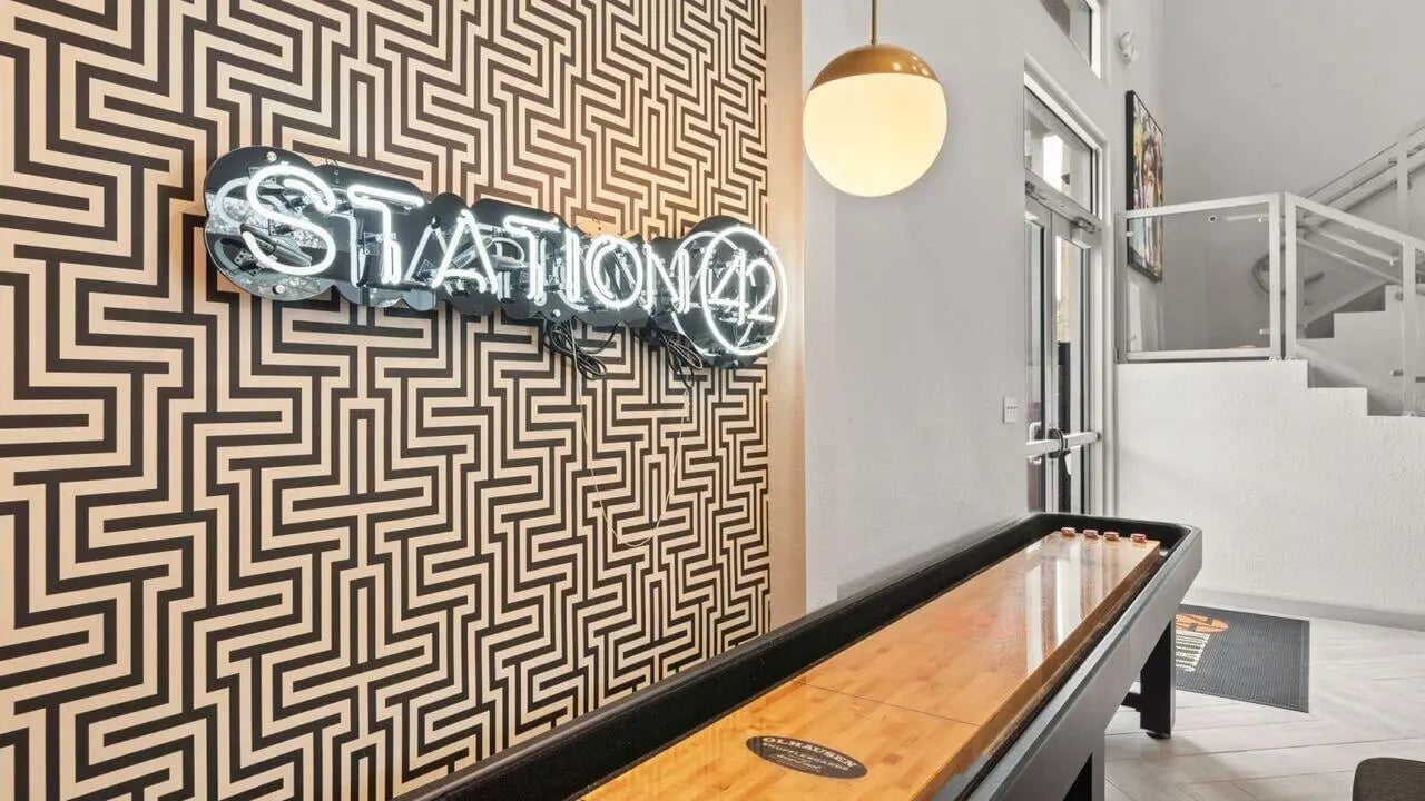 Neon STATION 42 sign shuffleboard and stairs game area at Station 42 in Tampa Student Accommodation