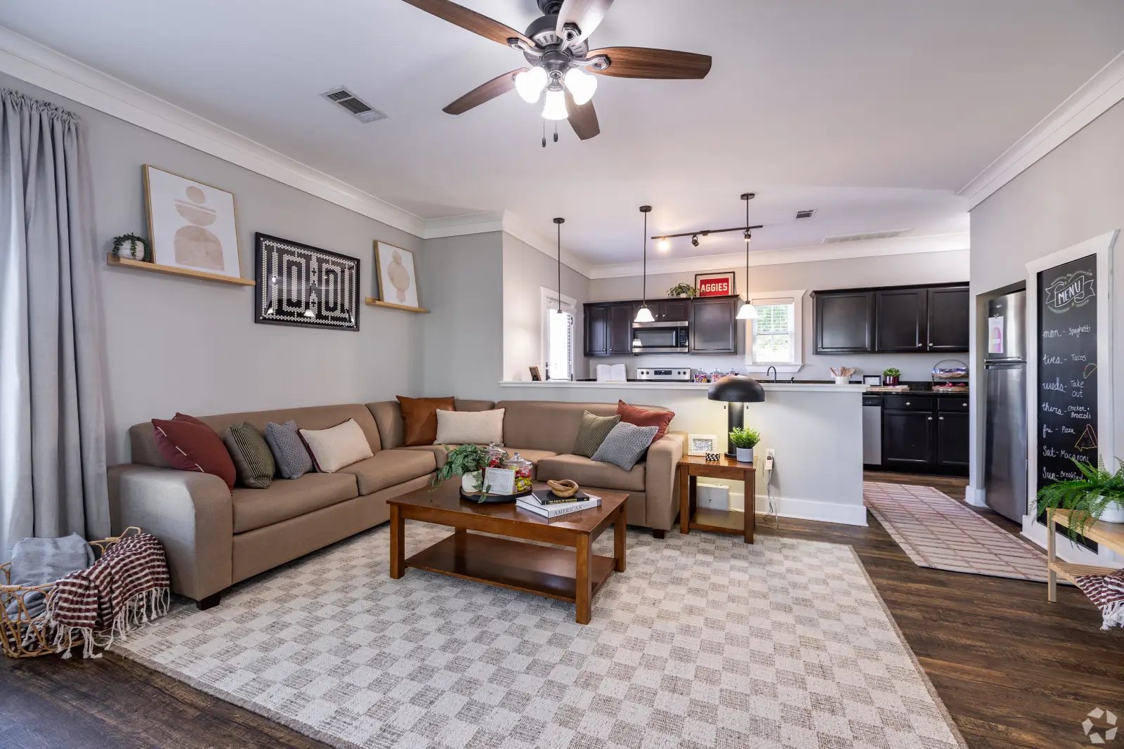 Sectional couch coffee table kitchen open living room at The Cottages of College Station in College Station Student Accommodation