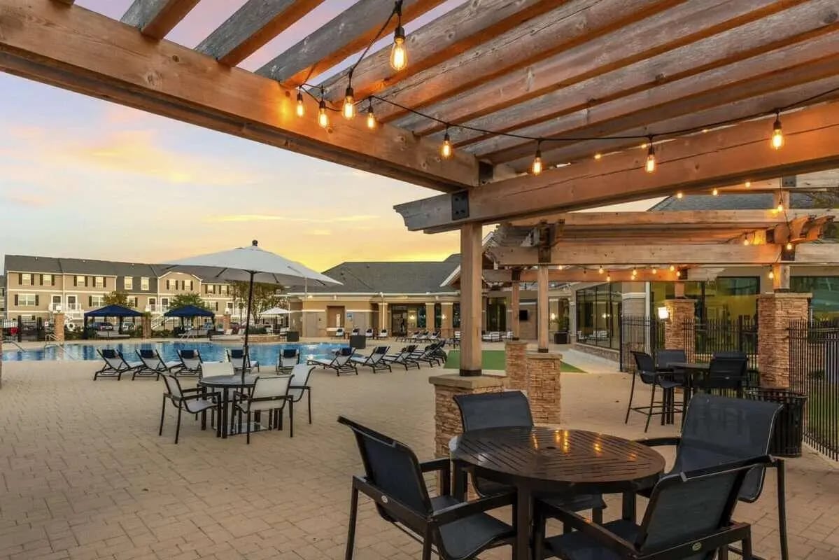 Pergola with string lights lounge chairs pool and buildings exterior at Copper Beech at San Marcos in San Marcos Student Accommodation