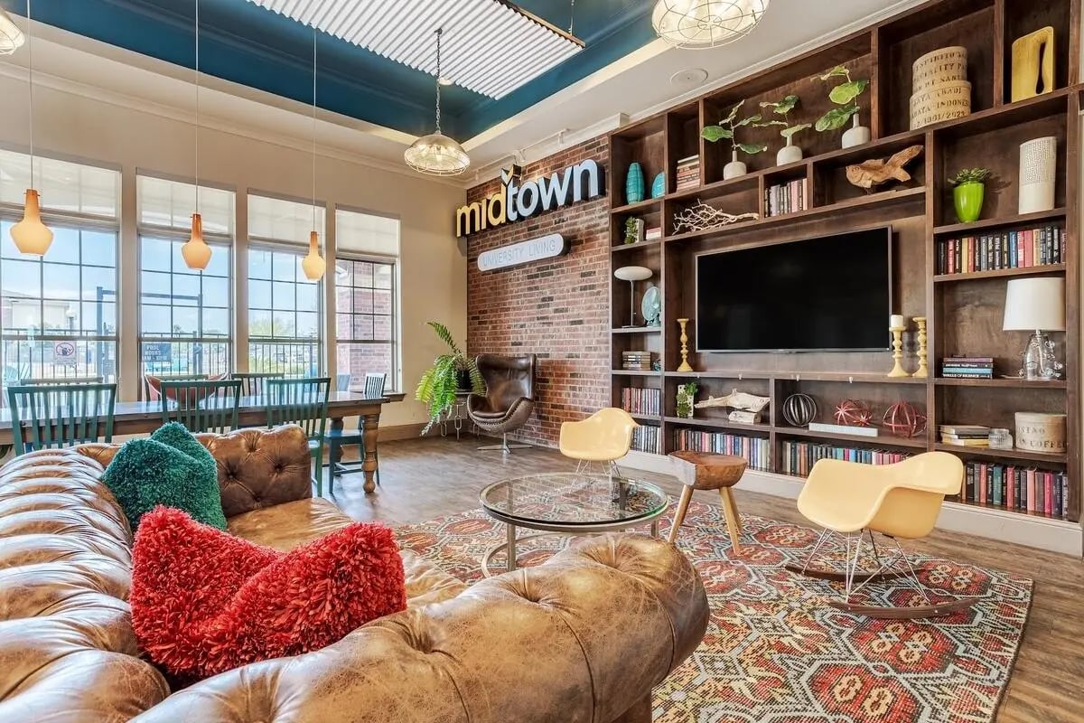 Leather sofa dining table TV bookshelf lounge area at Midtown Corpus Christi in Corpus Christi Student Accommodation