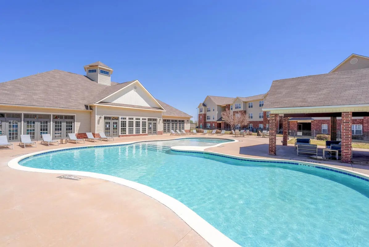 Pool lounge chairs buildings covered seating area exterior at The Grove at Lubbock in Lubbock Student Accommodation