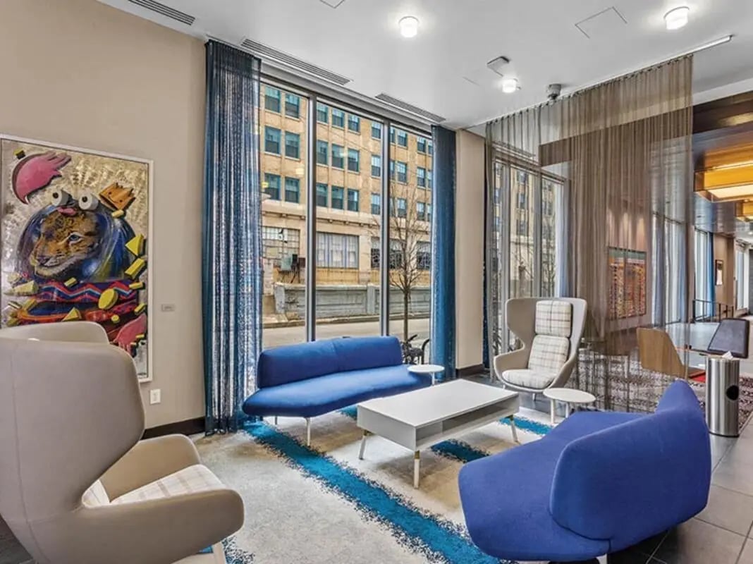 Blue sofas modern chairs abstract art living area at Chestnut Square in Philadelphia Student Accommodation