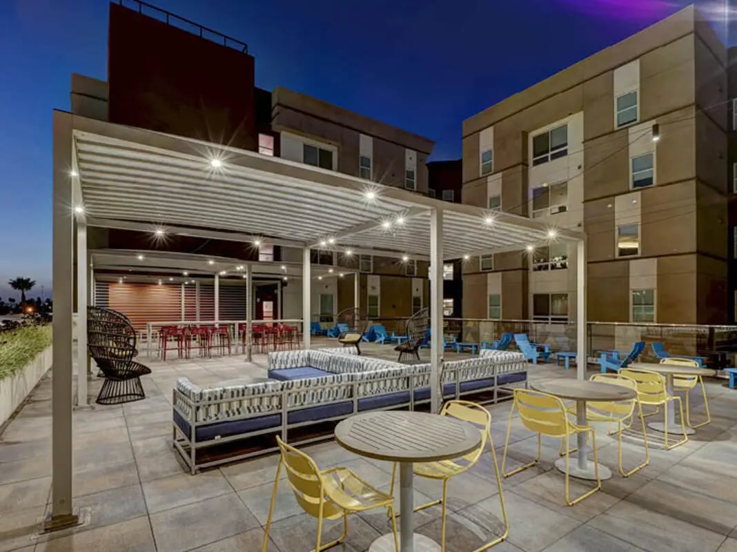 Patio seating with lounge couches tables chairs exterior at Currie Hall in Los Angeles Student Accommodation