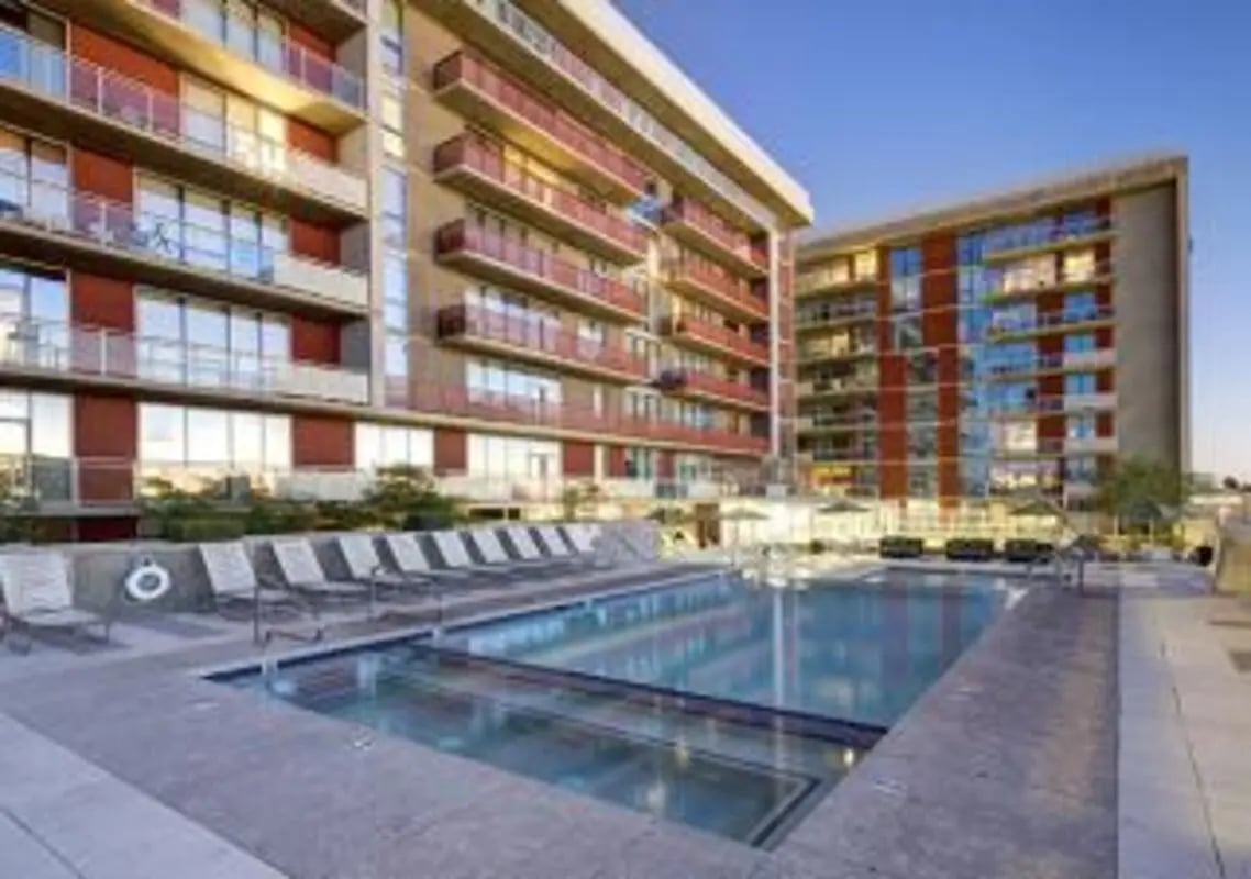 Apartment buildings with pool and lounge chairs exterior at 922 Place in Tempe Student Accommodation