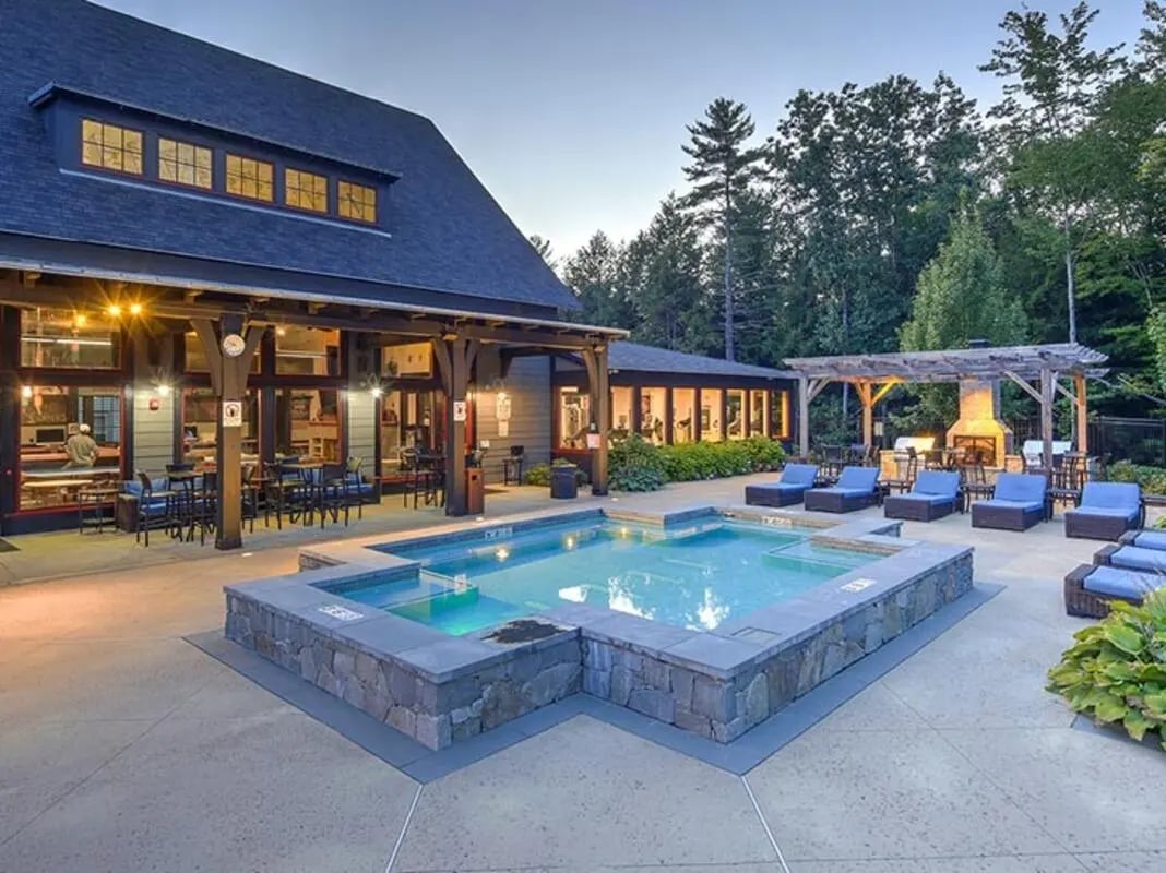 Pool and patio with lounge chairs and fireplace exterior at The Cottages of Durham in Durham Student Accommodation