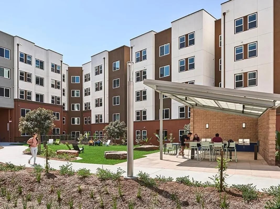 Apartment buildings with patio tables and grills exterior at Plaza Verde in Irvine Student Accommodation