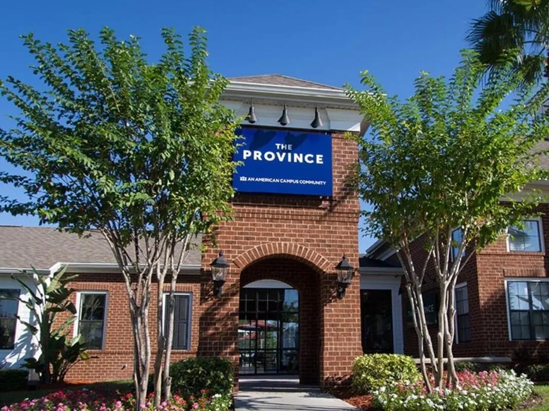 Brick building with entrance and trees exterior at The Province in Tampa Student Accommodation