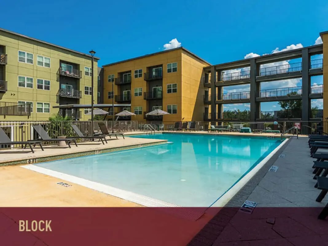Apartment buildings pool lounge chairs umbrellas exterior at Stadium Centre - The Block in Tallahassee Student Accommodation