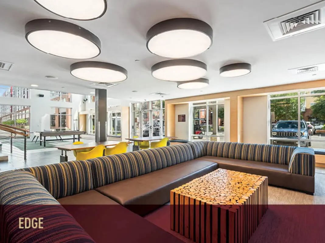 Sofa coffee table ping pong table yellow chairs lounge area at Stadium Centre - The Edge in Tallahassee Student Accommodation