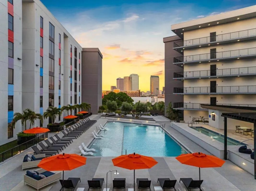 Pool lounge chairs umbrellas buildings city skyline exterior at Apella on Newport in Tampa Student Accommodation