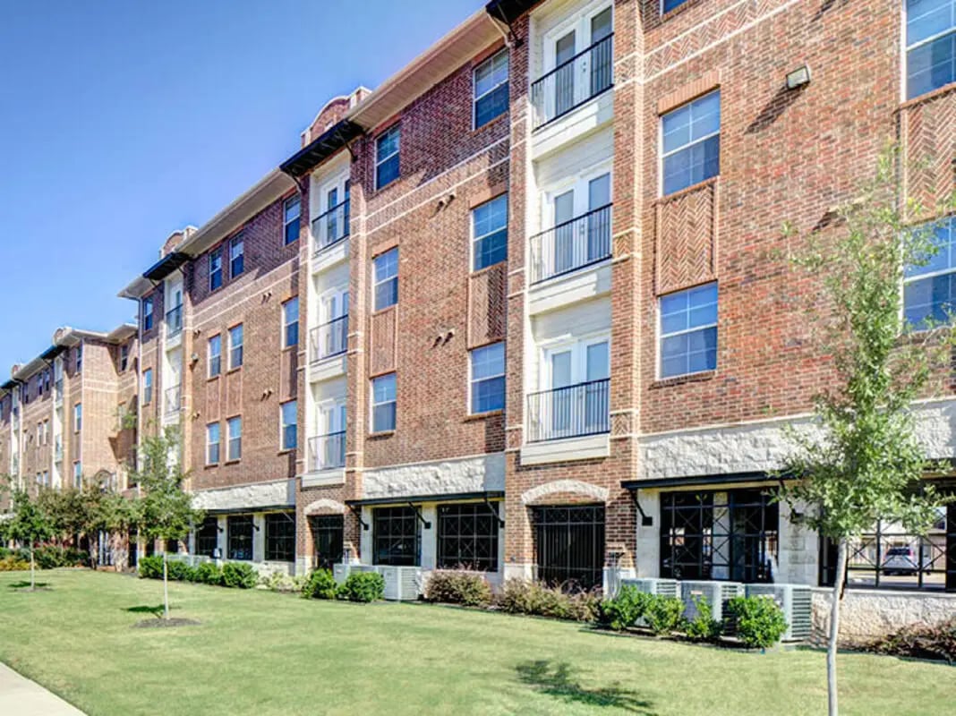 Brick apartment building with balconies and green lawn exterior at Union in Waco Student Accommodation