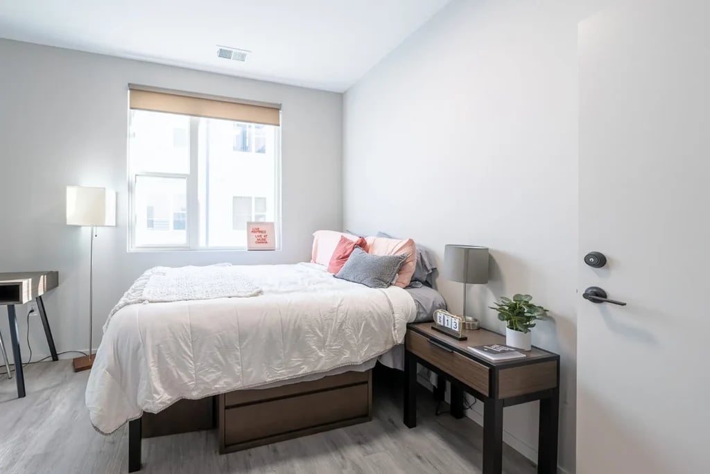 Bed desk lamp pillows nightstand plant Bedroom at Muse Omaha in Omaha Student Accommodation