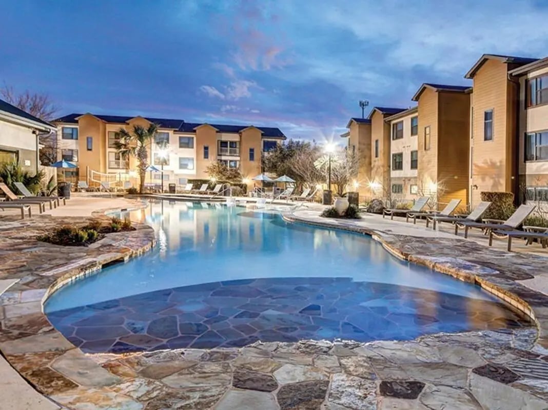 Pool with lounge chairs and buildings exterior at Villas at Babcock in San Antonio Student Accommodation