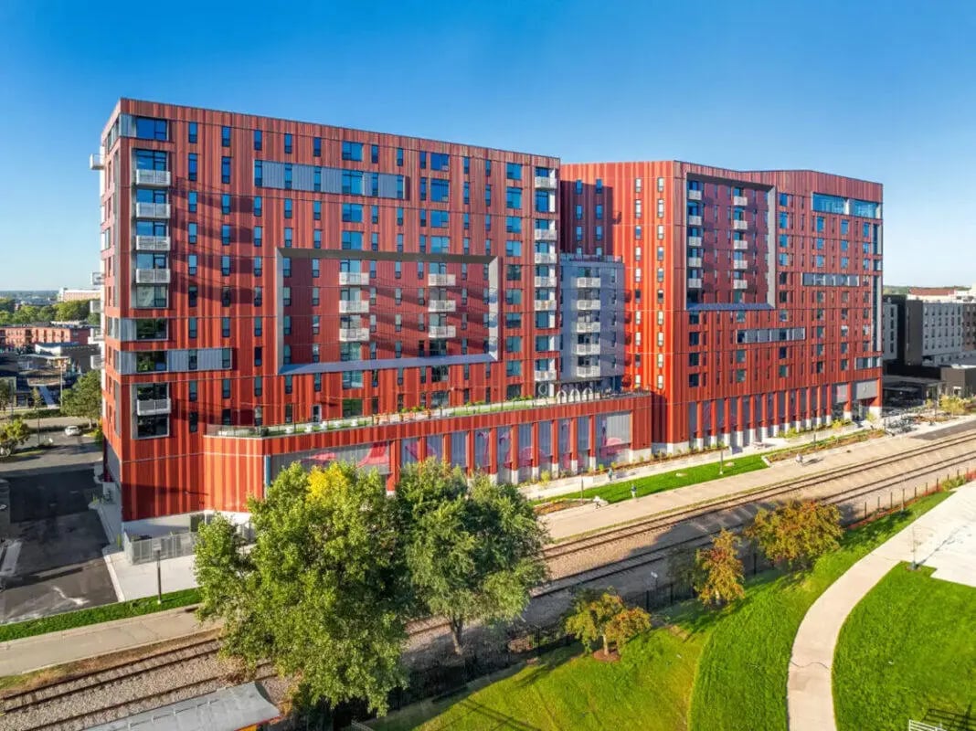 Modern red building with many balconies and windows exterior at Atmosphere Madison in Madison Student Accommodation