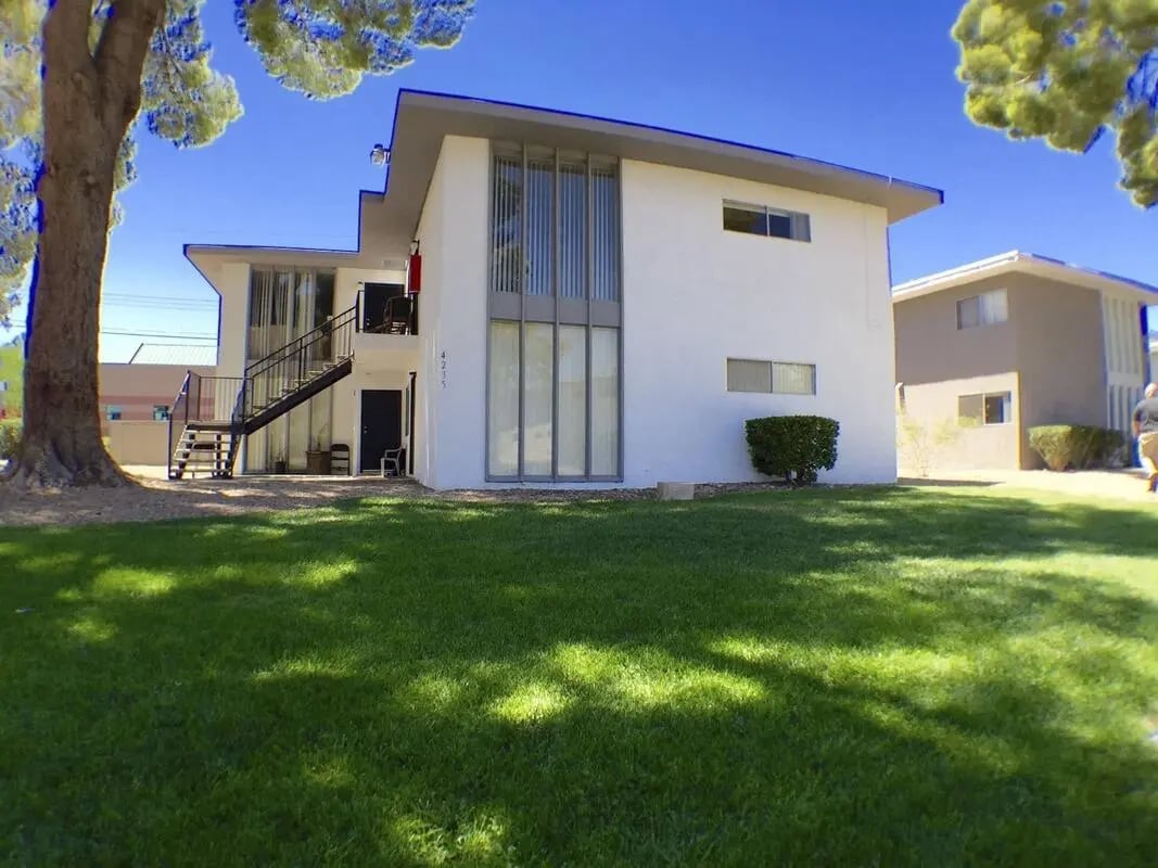White building with stairs and green lawn exterior at Legacy LV in Las Vegas Student Accommodation