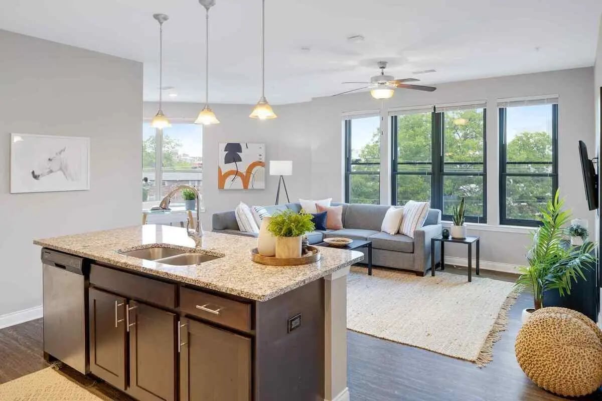 Kitchen island sink dishwasher sofa coffee table living room at Midtown Stillwater Student Apartments in Stillwater Student Accommodation