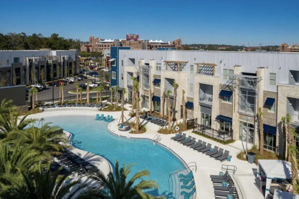 Modern apartment complex with swimming pool and loungers exterior at Stadium Enclave in Tallahassee Student Accommodation