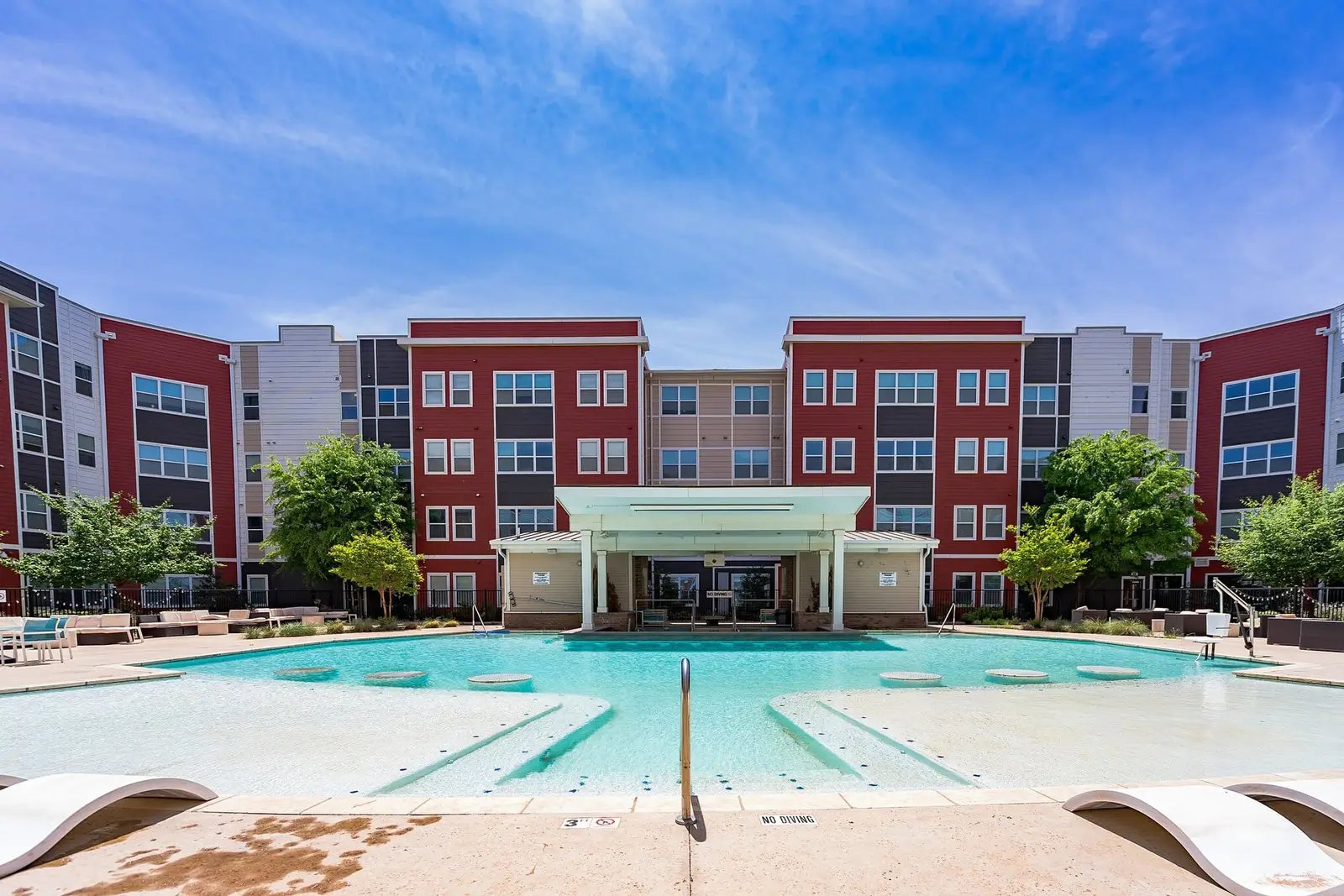 Modern apartment building with large swimming pool exterior at Park East Student Living in Lubbock Student Accommodation